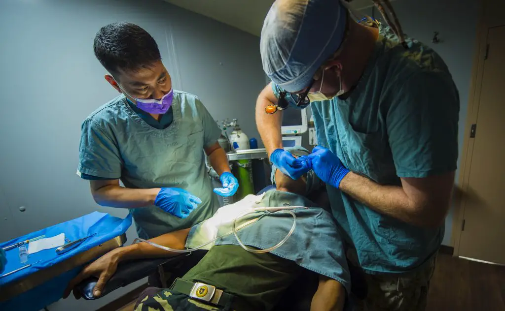 ROXAS CITY, Philippines (July 21, 2015) Philippine army Maj. Fernando Mojica Jr., dentist (left), observes Navy Lt. David Green, a dentist from Longmot, Colo., performs a dental procedure aboard the hospital ship USNS Mercy (T-AH 19) during Pacific Partnership 2015. Dentists conducted a subject matter expert exchange to share ideas and techniques to improve their dental practices. Mercy is currently in the Philippines for its third mission port of PP15. Pacific Partnership is in its 10th iteration and is the largest annual multilateral humanitarian assistance and disaster relief preparedness mission conducted in the Indo-Asia-Pacific region. While training for crisis conditions, Pacific Partnership missions to date have provided real world medical care to approximately 270,000 patients and veterinary services to more than 38,999 animals. Additionally, the mission has provided critical infrastructure development to host nations through more than 180 engineering projects. (U.S. Air Force Photo by Tech. Sgt. Araceli Alarcon/RELEASED)